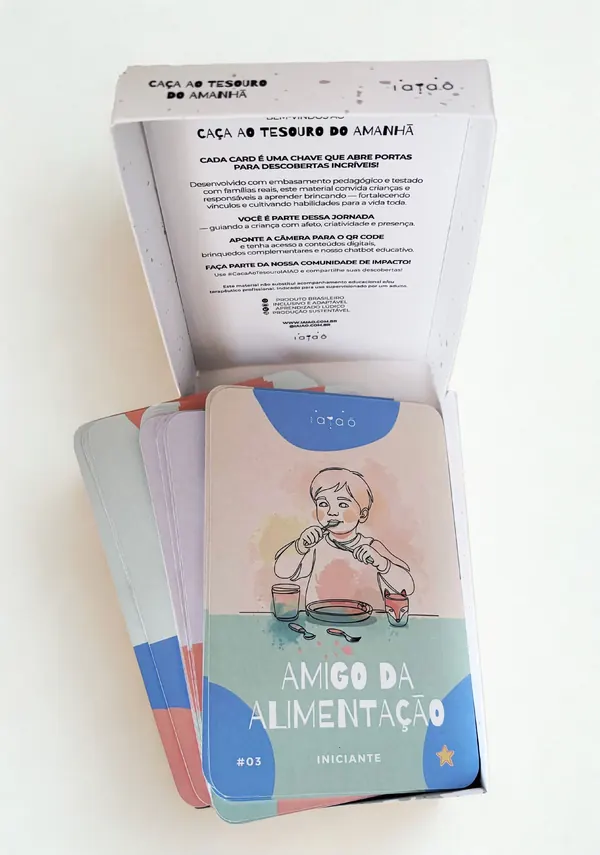 Caixa do kit aberta, com o texto de boas-vindas na tampa e o card Amigo da Alimentação por cima dos outros cards